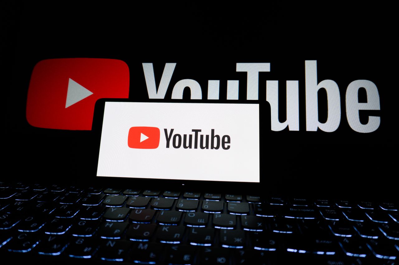 journey Close-up of YouTube logo displayed on a laptop screen in a dark environment.