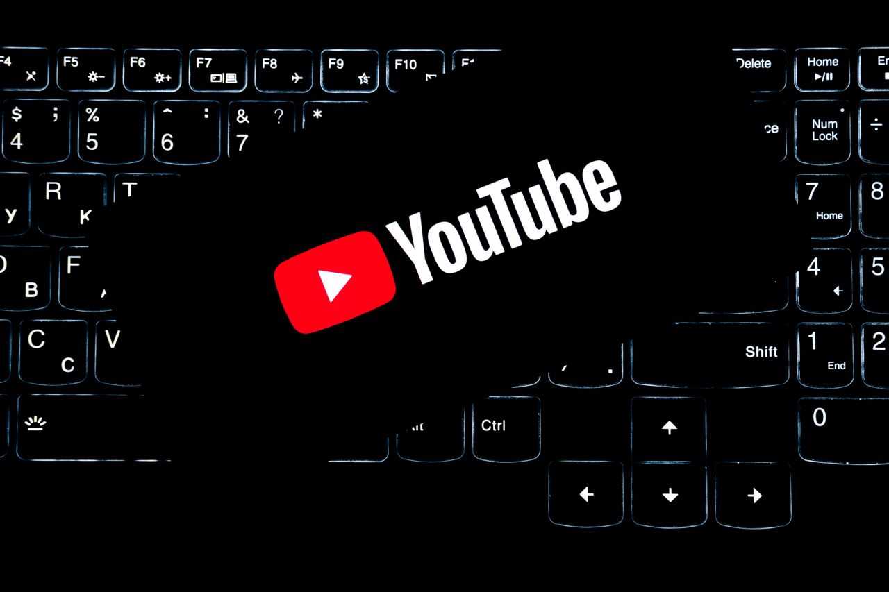 why-choose-us YouTube logo displayed on a backlit keyboard, representing digital media and online content creation.